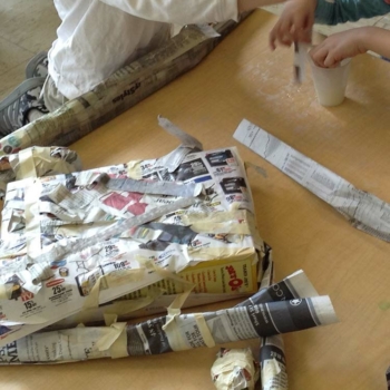 Students wrapping a box in newspaper as part of an arts integration project