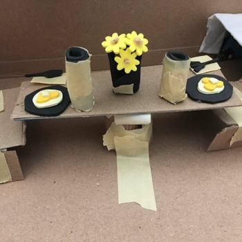 An arts integration project using various materials to depict a table at breakfast